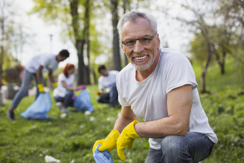 a senior male volunteers outside