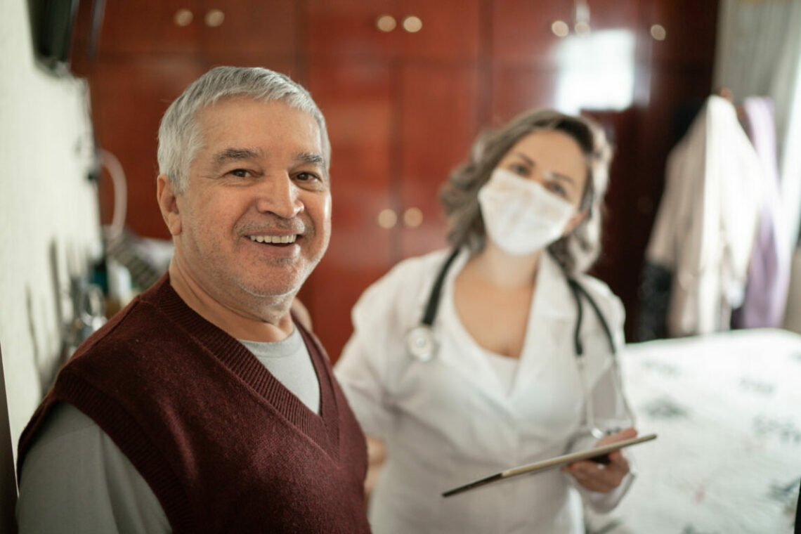 a senior man being treated by a nurse wearing a face mask